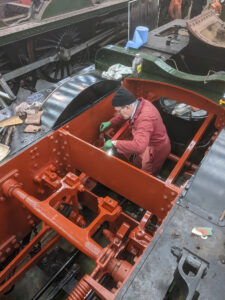 EMF volunteer Andrew Boucher is seen putting another coat of Venetian red paint on the valve gear while it was still readily accessible