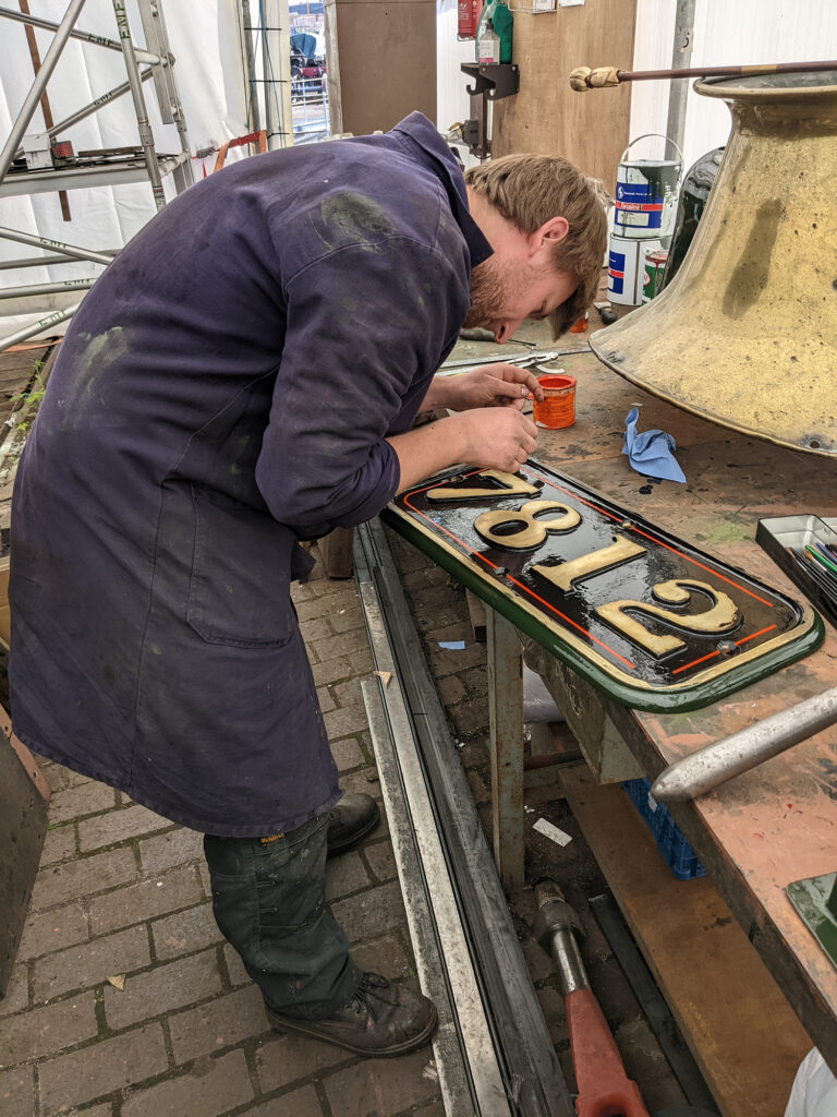 Some of the ‘finishing touches’ have also been completed in readiness for when they are needed. Here Scott is seen lining out one of the cab side numberplates [Photo: Adrian Hassell]