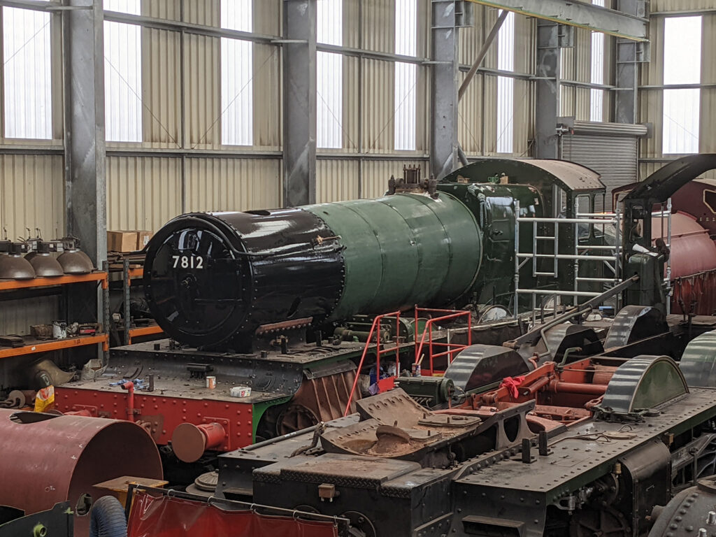 On 3rd May, 7812 Erlestoke Manor is seen with boiler and firebox now clad, BR green topcoat paint applied, with some rubbed down awaiting further coats, and the smokebox painted. [Photo: Adrian Hassell]:
